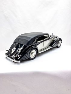 a black and silver model car sitting on top of a white table