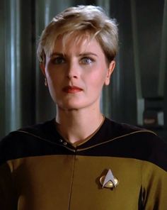 a woman with blonde hair wearing a star trek uniform