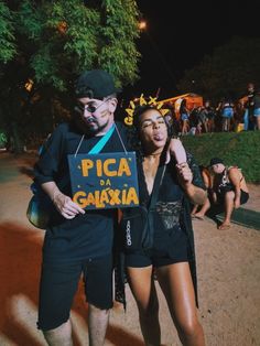 a man and woman standing next to each other holding a sign that says pica da garaxa