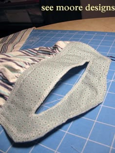 a pair of scissors sitting on top of a cutting board next to some cloths