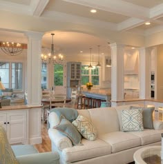 a living room filled with furniture next to a kitchen