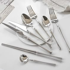 a set of silverware on a white table