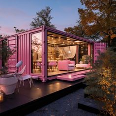 a pink container house is lit up at night