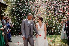 a bride and groom are walking through confetti