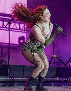 a woman with red hair is performing on stage