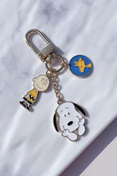 a keychain with two charms attached to it on a marble counter top,