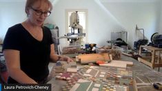 a woman standing in front of a table filled with different types of tiles and wood