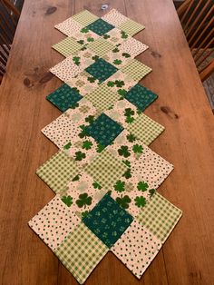 the table runner is made up of green and white squares with shamrocks on them