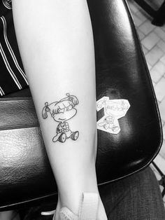 a black and white photo of a person's leg with a cartoon character tattoo on it