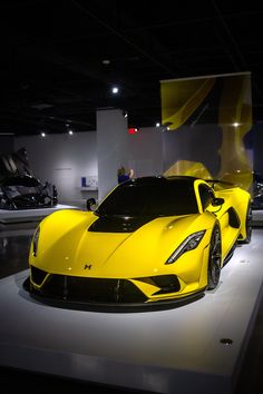 a yellow sports car on display in a showroom