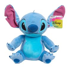 a blue stuffed animal with pink ears sitting next to a credit card