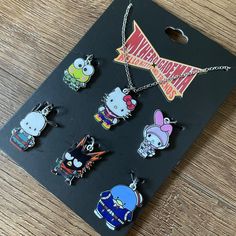 an assortment of cartoon character charms on a wooden table with a tag attached to it