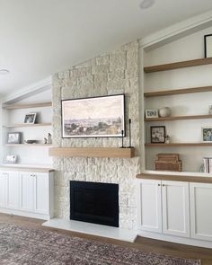 a living room with a fireplace, shelves and a rug on top of the floor