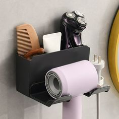 a hair dryer, combs, and other items in a holder on a wall