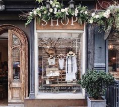 a store front with flowers and clothes on display