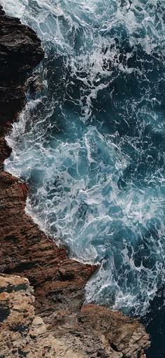 an ocean view with waves crashing on the rocks