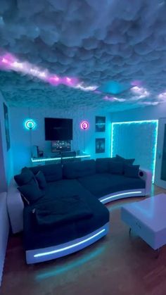 a living room filled with lots of furniture and lights on the ceiling, along with blue walls