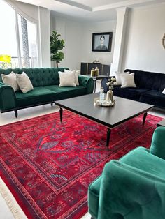 a living room filled with green couches and red rugs on top of a floor