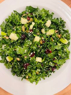 a white plate topped with a salad covered in nuts