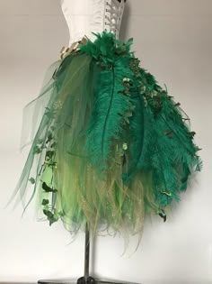 a dress made out of green feathers on a mannequin