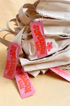 several bags with tags attached to them sitting on a table