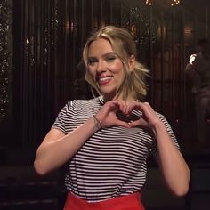 a woman making a heart with her hands