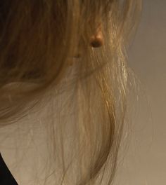 the back of a woman's head with her hair blowing in the wind,