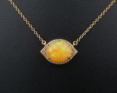 This beautiful necklace features a fixed pendant set with a gorgeous opal cabochon surrounded by a marquise shaped halo of bright white diamonds. The pendant is fixed on a 14k yellow gold chain.  This beautiful necklace is a great accent necklace to layer with others or perfect for everyday wear on its own. Metal Type:  14K Yellow Gold Notable Marks: 14k 585 Measurements: Chain: 16"-18" long; Pendant: 0.6"x 0.4"; 3 grams  Condition: Very good condition.  Jewelry Disclosure: We want you to love any piece you purchase from us. Please note that the majority of our jewelry items are pre-owned unless otherwise stated. This means they have the usual aspects of pre-owned jewelry, such as light signs of wear or patina. Vintage and antique gems may display light wear to facets commensurate for age. Fire Opal Necklace, Antique Jewelry Necklace, Yellow Gold Chain, Long Pendant, Opal Necklace, Beautiful Necklace, Diamond Halo, Pendant Set, White Diamonds