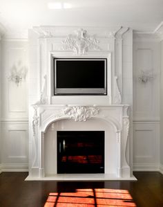 a white fireplace with a flat screen tv above it