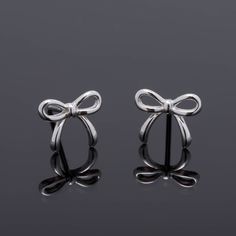 Pair of stud Earrings of delicate design in the form of a bow, made in Real 925 silver in a minimalist style, ideal gift for girl, teenager or woman. Material: 100% 925 Sterling Silver. Bolt size: 6mm x 10mm. Weight: 0.66 grams per pair. Tips for the care of your Silver Jewelry: * Keep your silver jewelry in a cool and dry place to avoid oxidation. * Avoid exposing them to water, perfume, and harsh chemicals. * Clean your Silver jewelry relatively frequently to maintain its shine and beauty. All Silver Earrings Aesthetic, Small Silver Earrings, Ribbon Earrings, Gift Bow, Water Perfume, Ear Jacket Earring, Silver Bow, Small Earrings Studs, Delicate Design