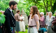 a man and woman standing next to each other in front of an outdoor wedding ceremony