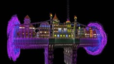 the tower bridge is lit up in purple and blue lights, with buildings on both sides