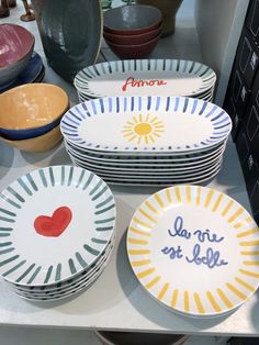 plates and bowls are on display in a shop window, with the words love written on them