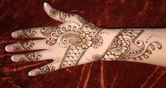 a woman's hand with henna tattoos on it