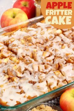 an apple fritter cake with white icing in a glass dish next to apples