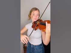 a woman holding a violin in her right hand