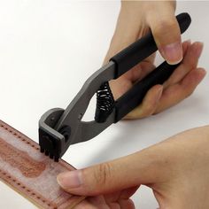 someone is cutting leather with a pair of scissors