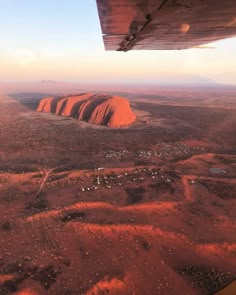 the view from an airplane looking down at aye rock in the outback desert, australia