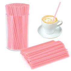 a cup and saucer with pink straws next to it