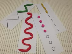 paper cut out to look like a snake and other things on the table with scissors