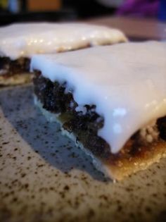 two pieces of cake sitting on top of a counter covered in frosting and icing