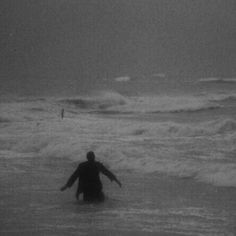 a person standing in the ocean with their arms outstretched