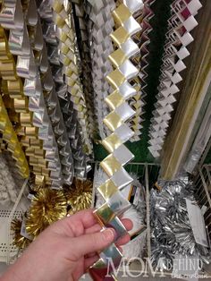 a hand is holding some tinsel in front of many different colored tinsels