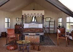 a bedroom with a canopy bed sitting inside of it's walls and ceiling covered in curtains