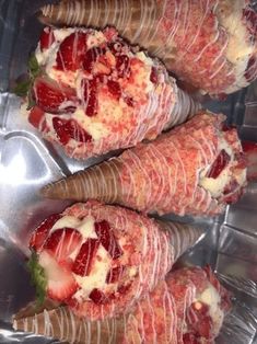 some very tasty looking desserts with strawberries and cream on them in a metal container