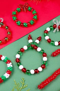 christmas beaded bracelets and necklaces are displayed on a green surface next to red and white decorations