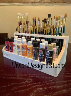 a wooden display with lots of paint and brushes on it