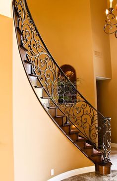 an elegant staircase with wrought iron railing and handrail