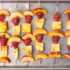 fruit and cheese skewers on a tray ready to be cooked in the oven