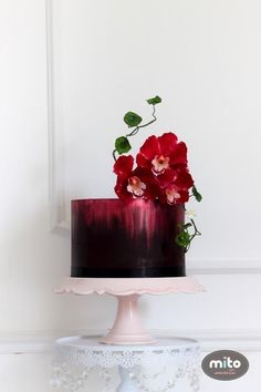 a red and black cake with flowers on top is featured in an instagram post